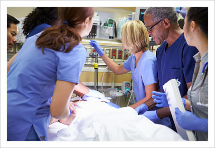 Picture of a patient in the ER with a team of Nurses and Doctors (two males and 4 females).